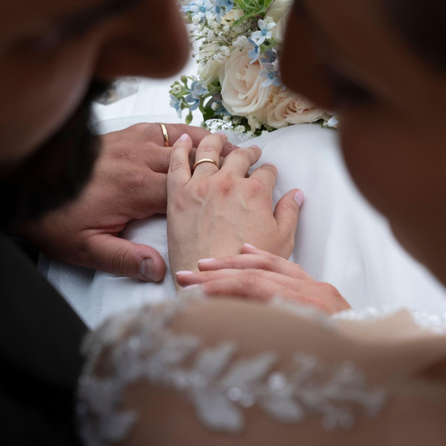 Dettaglio delle mani degli sposi con le fedi